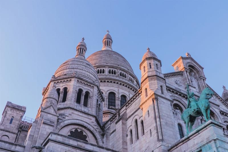La majestueuse Basilique du Sacré-Cœur de Montmartre, symbole des églises catholiques de Paris, dominant la ville avec son style unique.